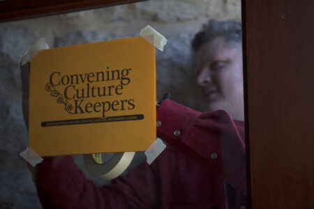Peter helps setup Parish Hall for Convening Culture Keepers Peter puts up a sign for CCK